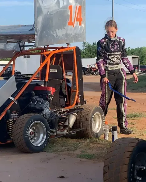 Ambria Hunter in a custom suit beside her sprint car