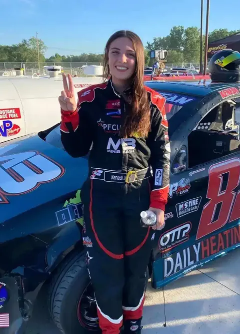 Kenedi Jernigan beside her number 88 car in her custom suit